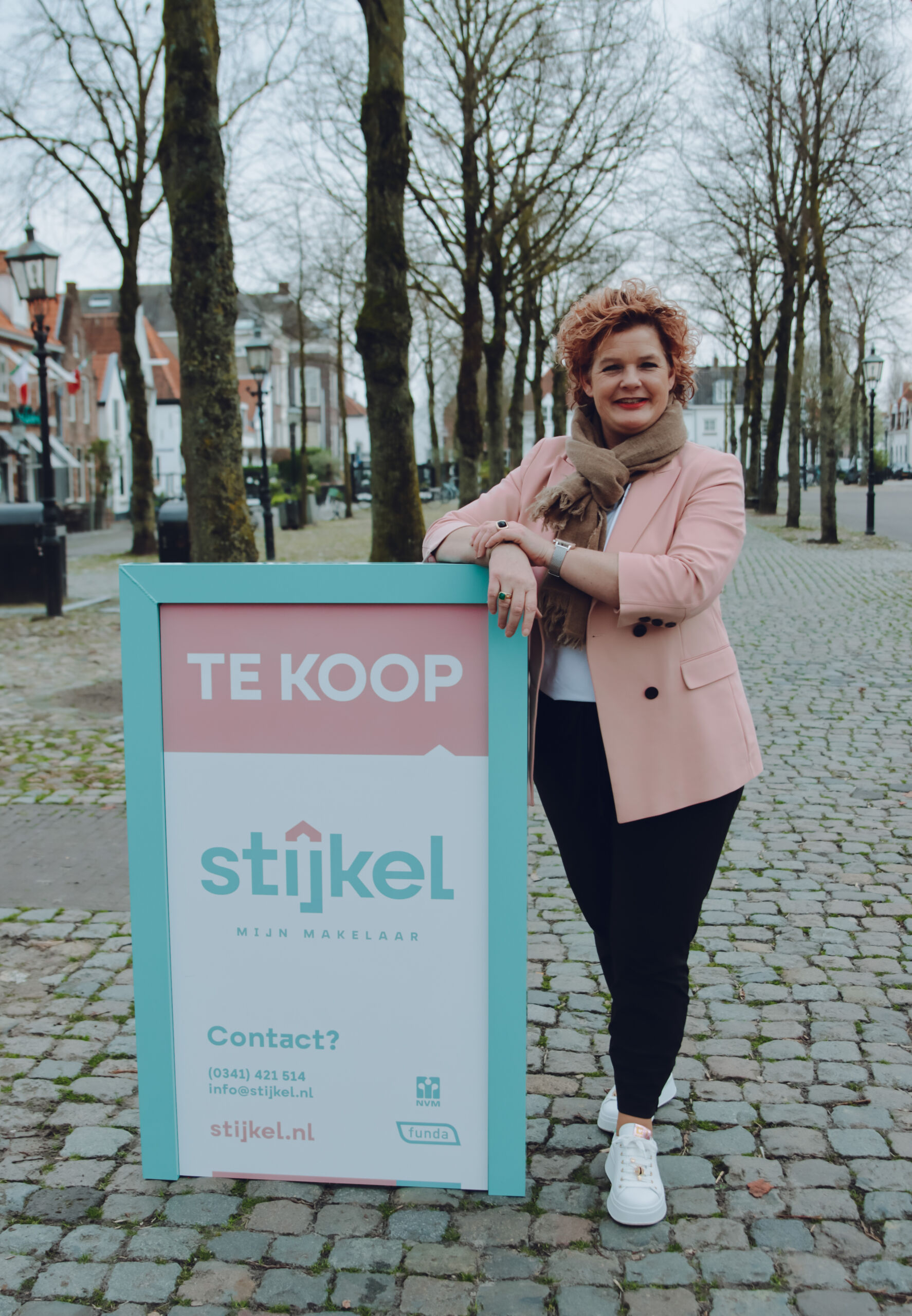 Op de foto Marieke Stijkel die op de Vischmarkt in Harderwijk staat met een verkoopbord